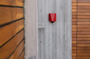 Red Easee charger mounted on concrete wall
